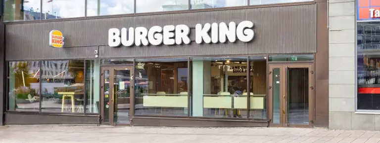 Burger King -ravintola julkisivullaan kadulla, isot ikkunat ja näkyvällä brändätyllä tekstillä BURGER KING.